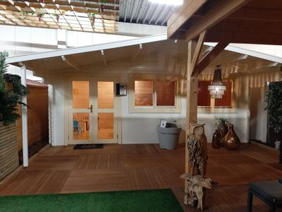 Tuindeco Piet blokhut 595x300 cm + luifel 200 cm - inclusief zwarte dakshingles, dakgoot, binnenvloer en composiet funderingsbalken - Showmodel Numansdorp- Zadeldak- Onbehandeld vurenhout- Tuindeco