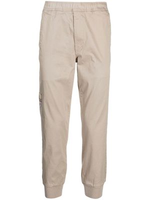 AAPE BY *A BATHING APE® pantalon fuselé à logo imprimé - Marron