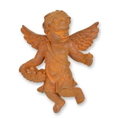 A RUSTY CAST IRON WALL MOUNT PUTTO HOLDING A FRUIT BASKET