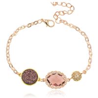 Goudkleurige verstelbare dames armband met roze glassteen - thumbnail