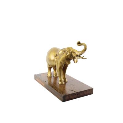 A BRONZE SCULPTURE OF AN ELEPHANT MOUNTED ON A WOODEN PLANK