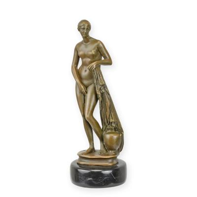 A BRONZE SCULPTURE OF A WOMAN STANDING AGAINST A COLUMN