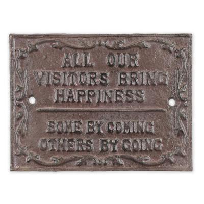 A CAST IRON "ALL OUR VISITORS BRING HAPPINESS" PLAQUE