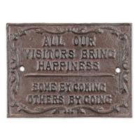 A CAST IRON "ALL OUR VISITORS BRING HAPPINESS" PLAQUE