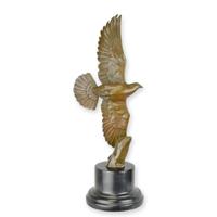 A BRONZE SCULPTURE OF A PIGEON IN A FLIGHT