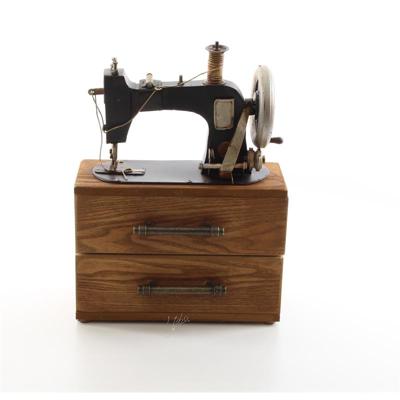 A TIN MODEL OF A SEWING MACHINE STORAGE BOX