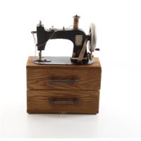 A TIN MODEL OF A SEWING MACHINE STORAGE BOX