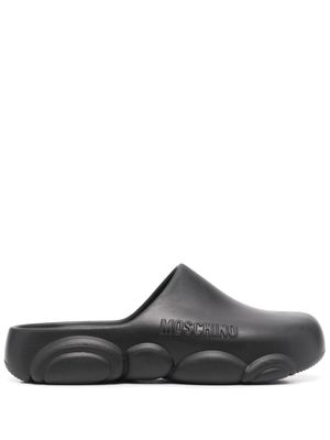 Moschino mules à logo embossé - Noir