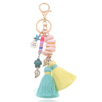 Handgemaakte Ibiza sleutelhanger goudkleurig blauw geel met schelpjes