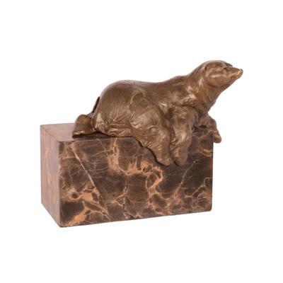 A BRONZE SCULPTURE OF A LYING POLAR BEAR