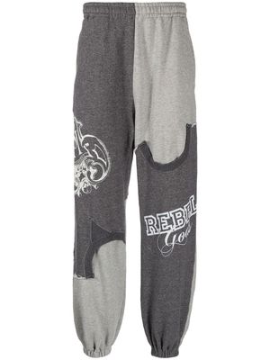 Undercoverism pantalon de jogging à imprimé graphique - Gris