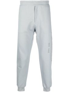 Alexander McQueen pantalon de jogging en coton à logo imprimé - Gris