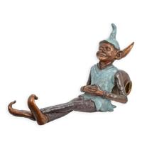 A BRONZE SCULPTURE OF A GOBLIN LEANING AGAINST A JAR