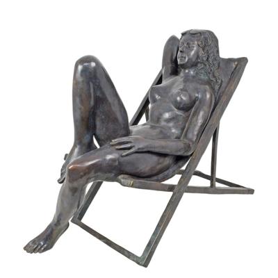 A BRONZE SCULPTURE OF A FEMALE NUDE IN BEACH CHAIR