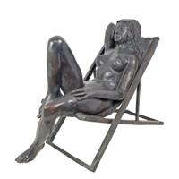 A BRONZE SCULPTURE OF A FEMALE NUDE IN BEACH CHAIR