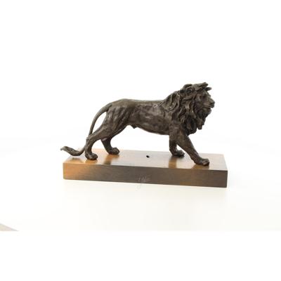 A BRONZE SCULPTURE OF A LION MOUNTED ON A WOODEN PLANK