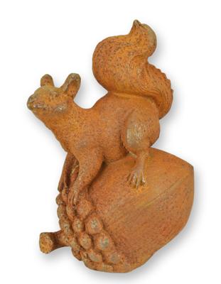 A RUSTY CAST IRON FIGURINE OF A SQUIRREL ON AN ACORN