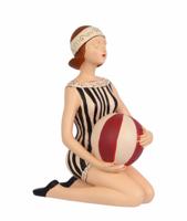 A RESIN FIGURINE OF A LADY WITH BEACHBALL