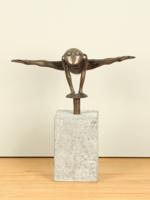 Bronzen kikker jump zwevend boven een sokkel