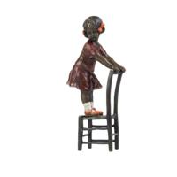 A BRONZE SCULPTURE OF A GIRL ON STOOL