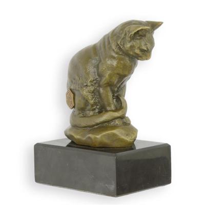 A BRONZE SCULPTURE OF A CAT LOOKING DOWN ON A MARBLE BASE