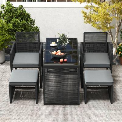 5-Delige PE Rieten Tuinmeubelset Buitenset met Kussens Ruimtebesparende Rotan Tuinstoel en Gehard Glazen Tafel met Voetenbankjes