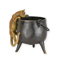 A BRONZE SCULPTURE OF A CAT CLIMBING IN A POT